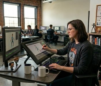 Professional animator working on character animation using a digital drawing tablet in a modern motion graphics and animation studio.